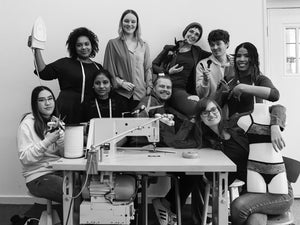 Danaë Trans-Missie team sitting around a sewing machine in their Netherlands studio